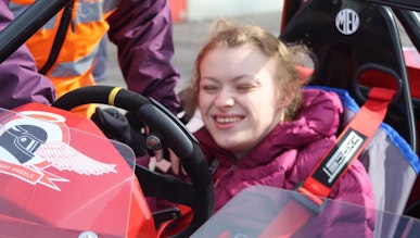Chloe in the driving seat of the race car