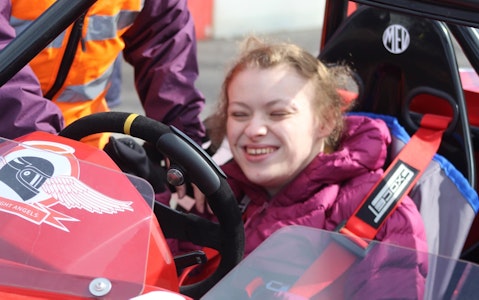 Chloe in the driving seat of the race car